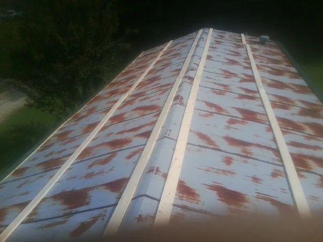Rusted metal roof panels with new wood purlins before replacement — Storm Damage Roof Repair in Ranson by Roofing Brothers