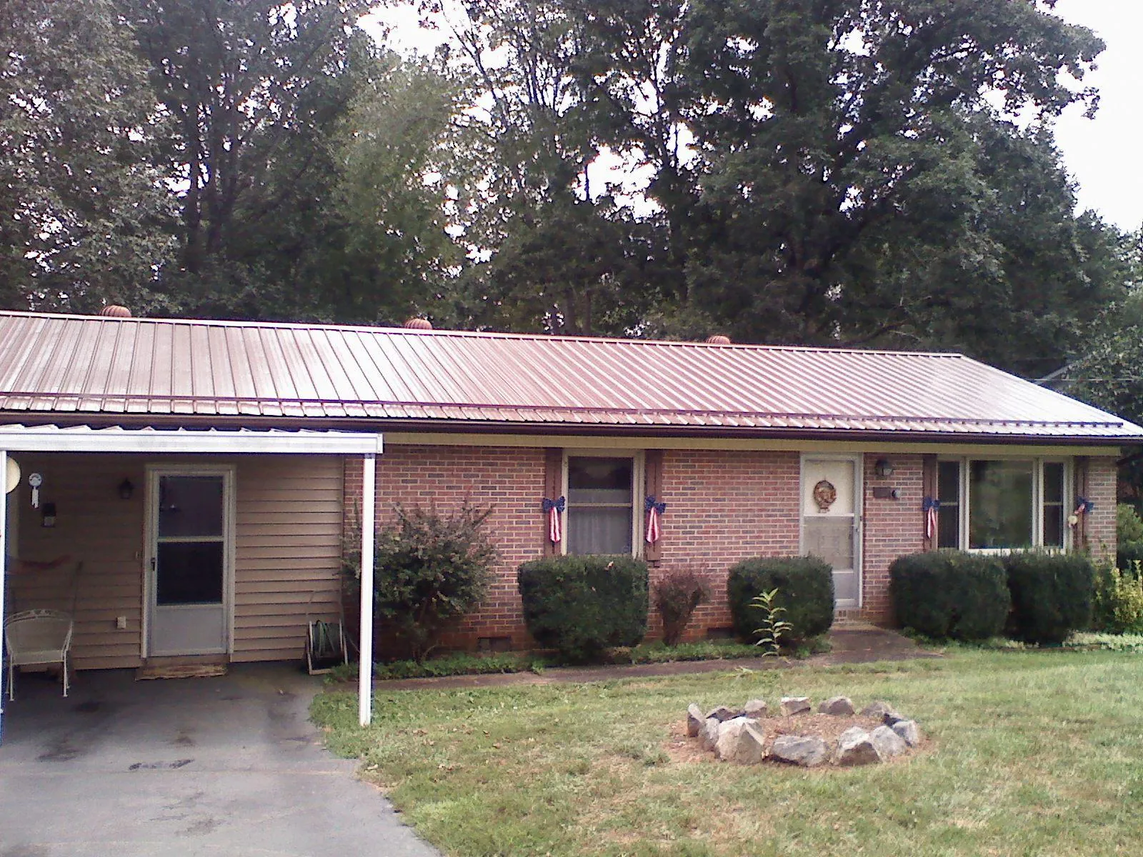 Bronze metal roof and carport on a brick ranch home — Roof Repair work by our crew in Ranson